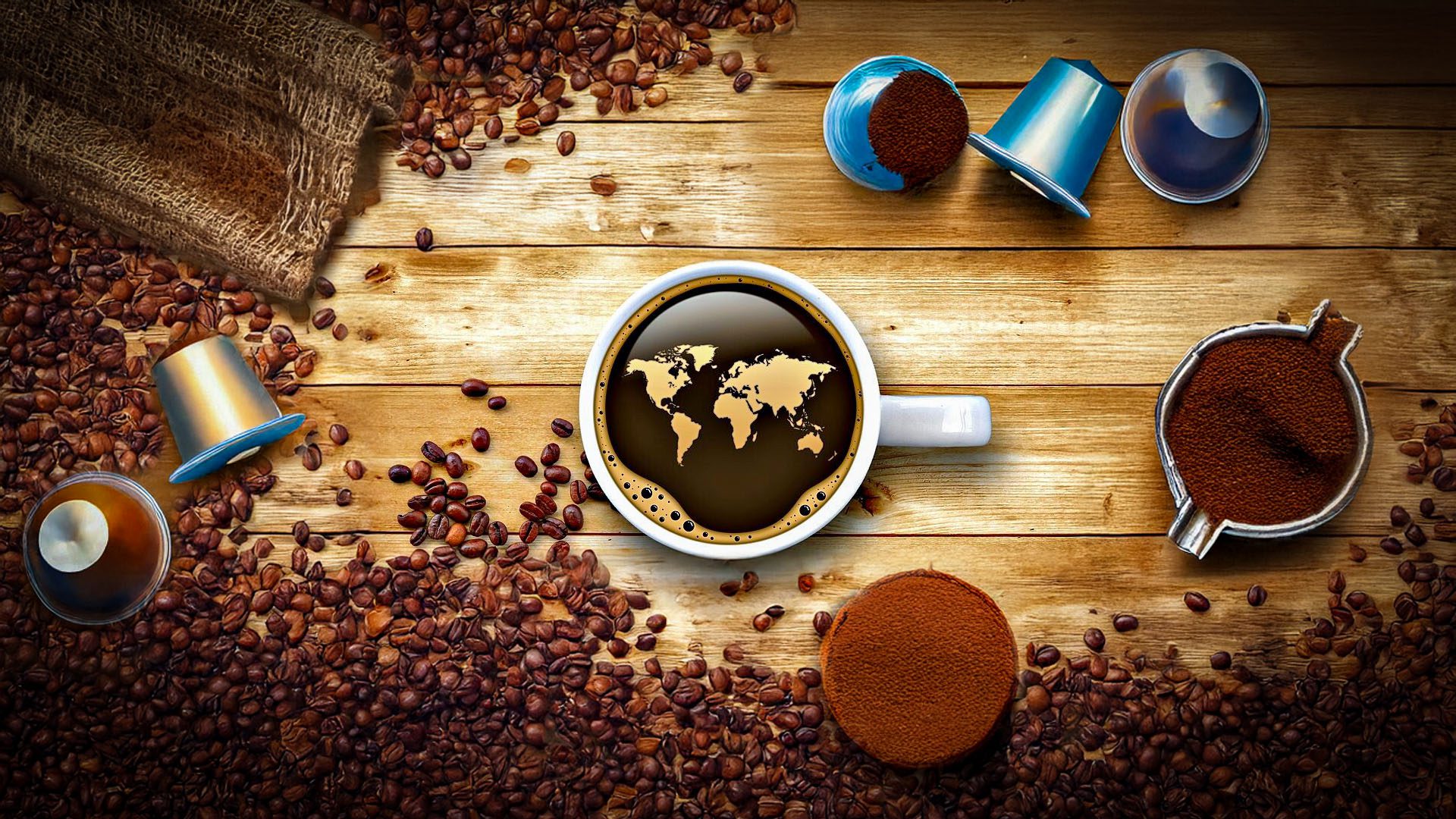 Tazza di caffè vista dall’alto con mappa del mondo sulla superficie, circondata da chicchi, capsule, cialde e polvere: rappresentazione del confronto tra caffè in grani e in capsule.